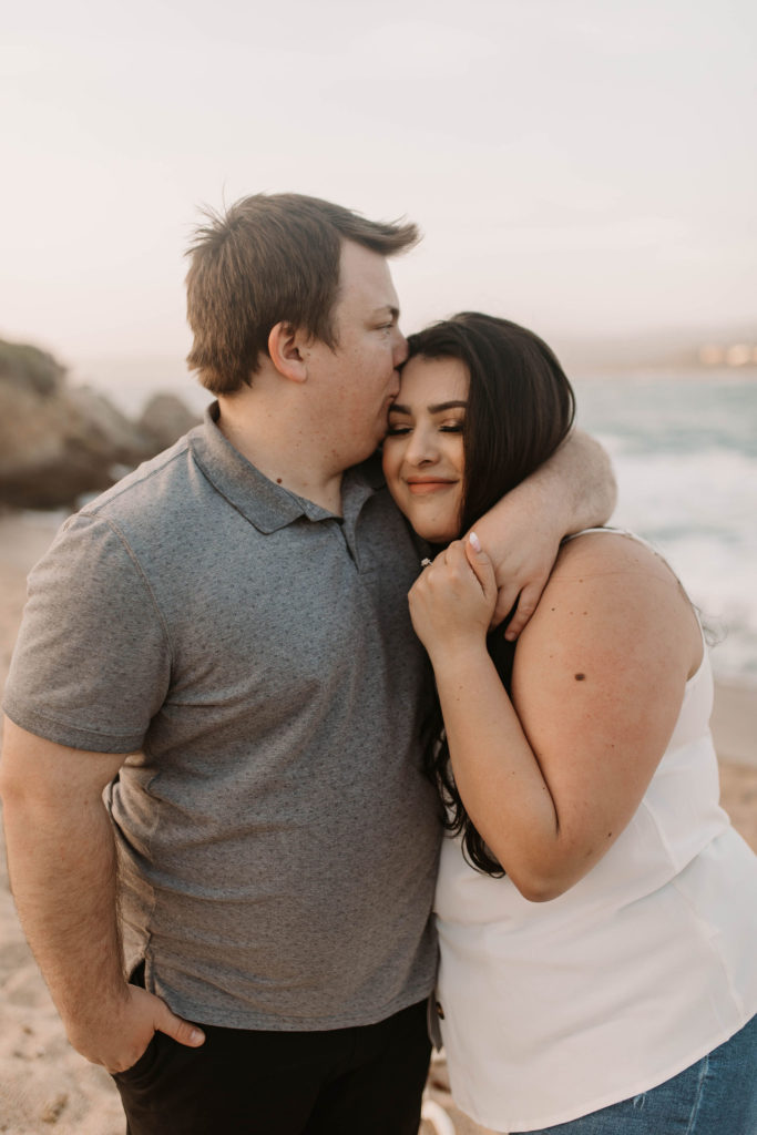 couple posing on the beach for their engagement photos in big sur california