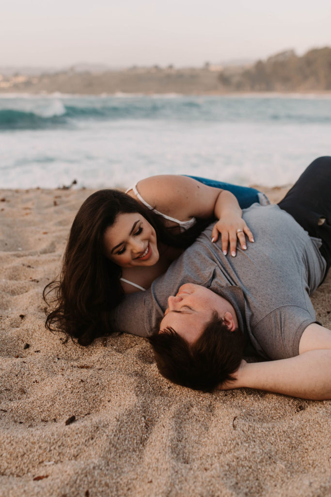 couple posing on the beach for their engagement photos in big sur california