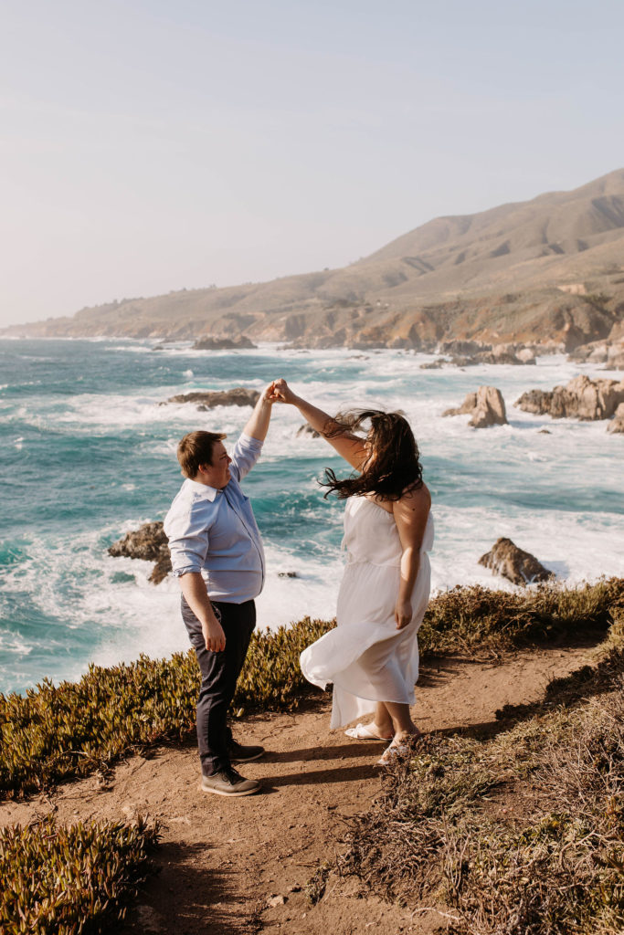 couple posing on the beach for their engagement photos in big sur california