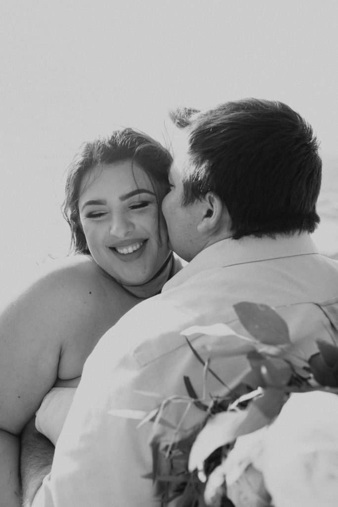 couple posing on the beach for their engagement photos in big sur california