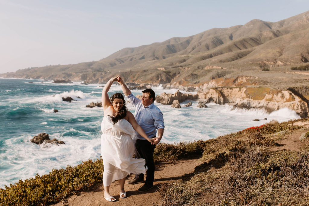 couple posing on the beach for their engagement photos in big sur california