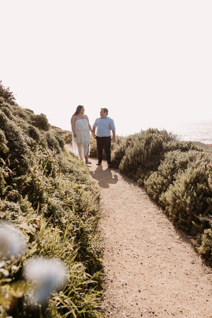 couple posing on the beach for their engagement photos in big sur california