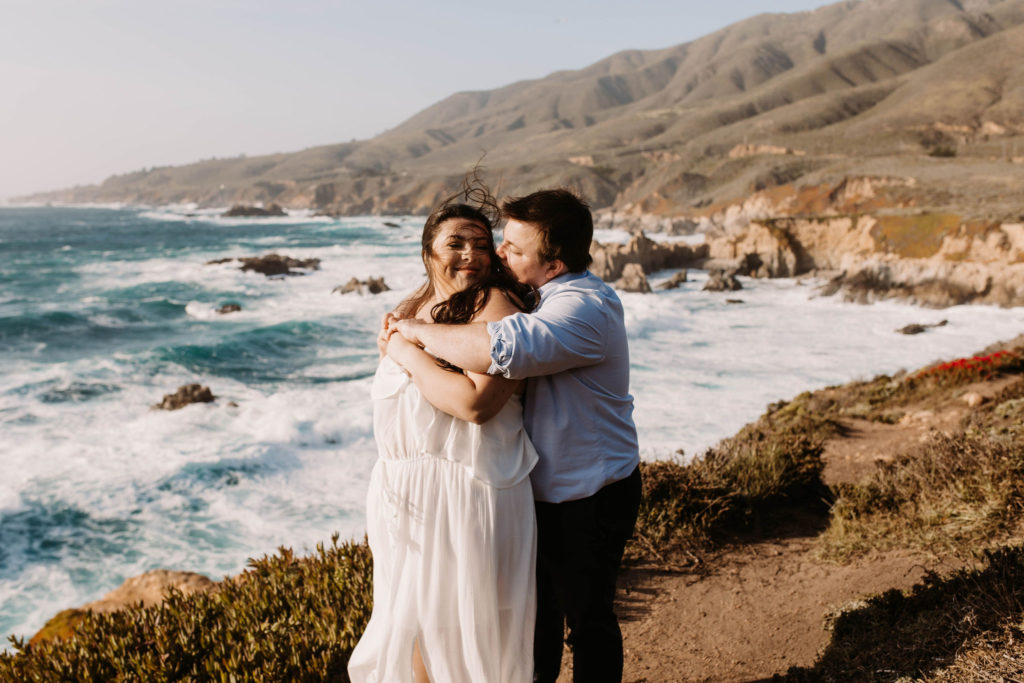 couple posing on the beach for their engagement photos in big sur california