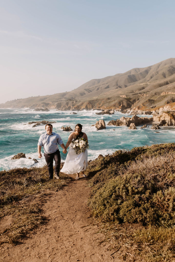 couple posing on the beach for their engagement photos in big sur california