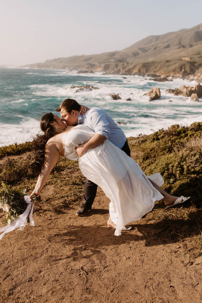 couple posing on the beach for their engagement photos in big sur california