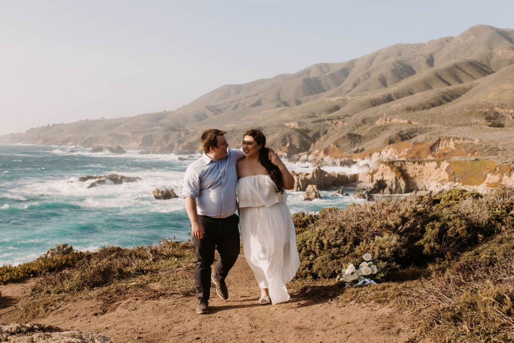 couple posing on the beach for their engagement photos in big sur california