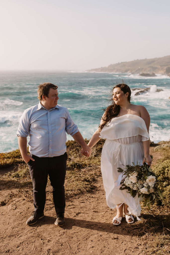 couple posing on the beach for their engagement photos in big sur california