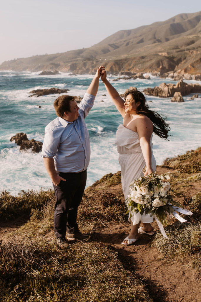 couple posing on the beach for their engagement photos in big sur california