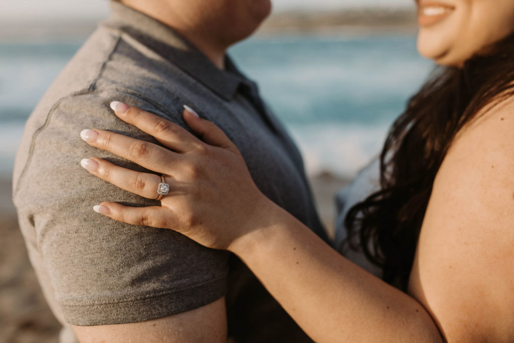 couple posing on the beach for their engagement photos in big sur california