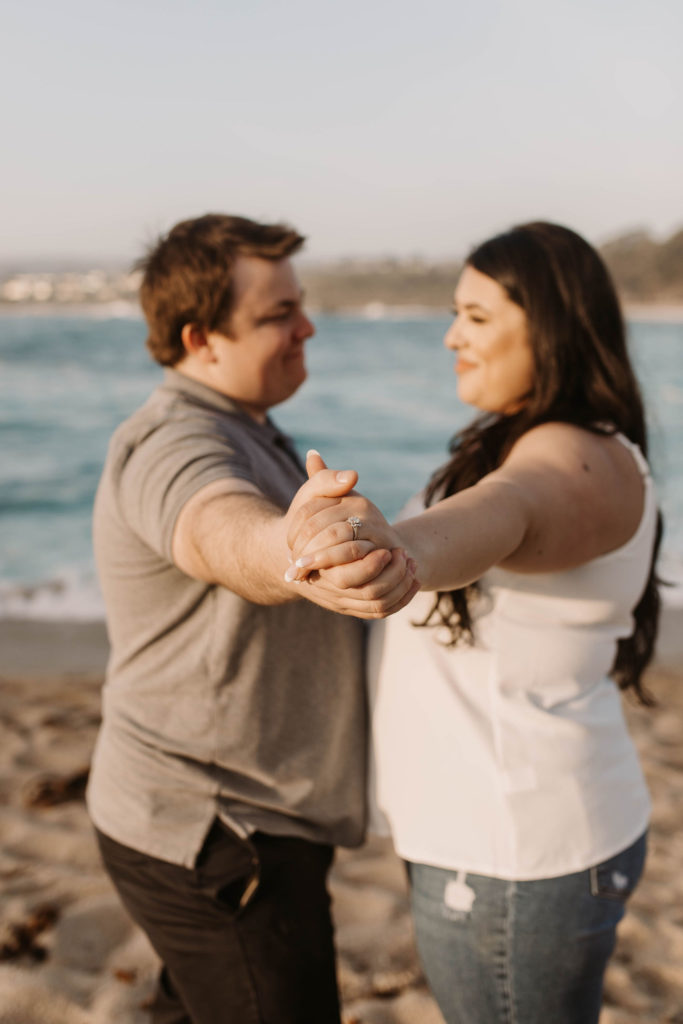 couple posing on the beach for their engagement photos in big sur california