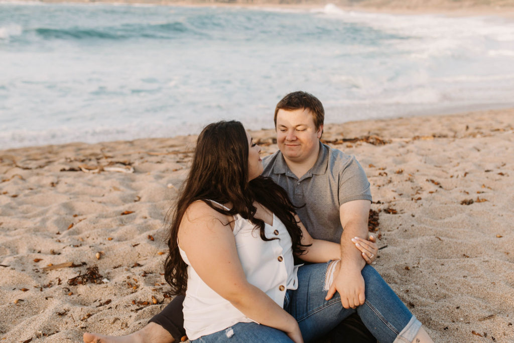 couple posing on the beach for their engagement photos in big sur california