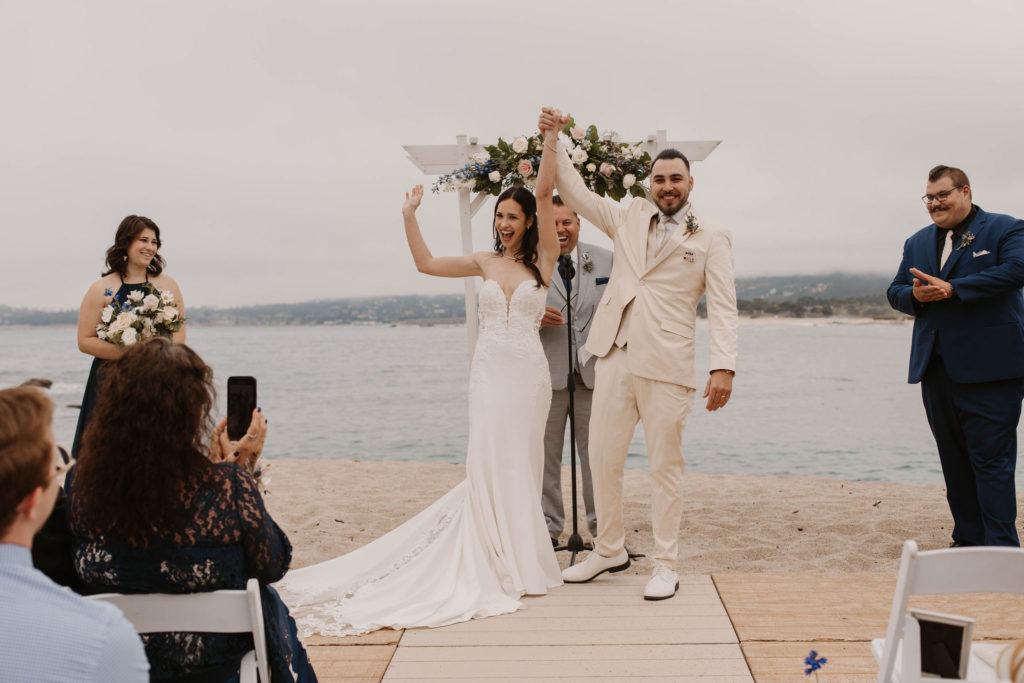 bride and groom celebrating their wedding ceremony on the beach