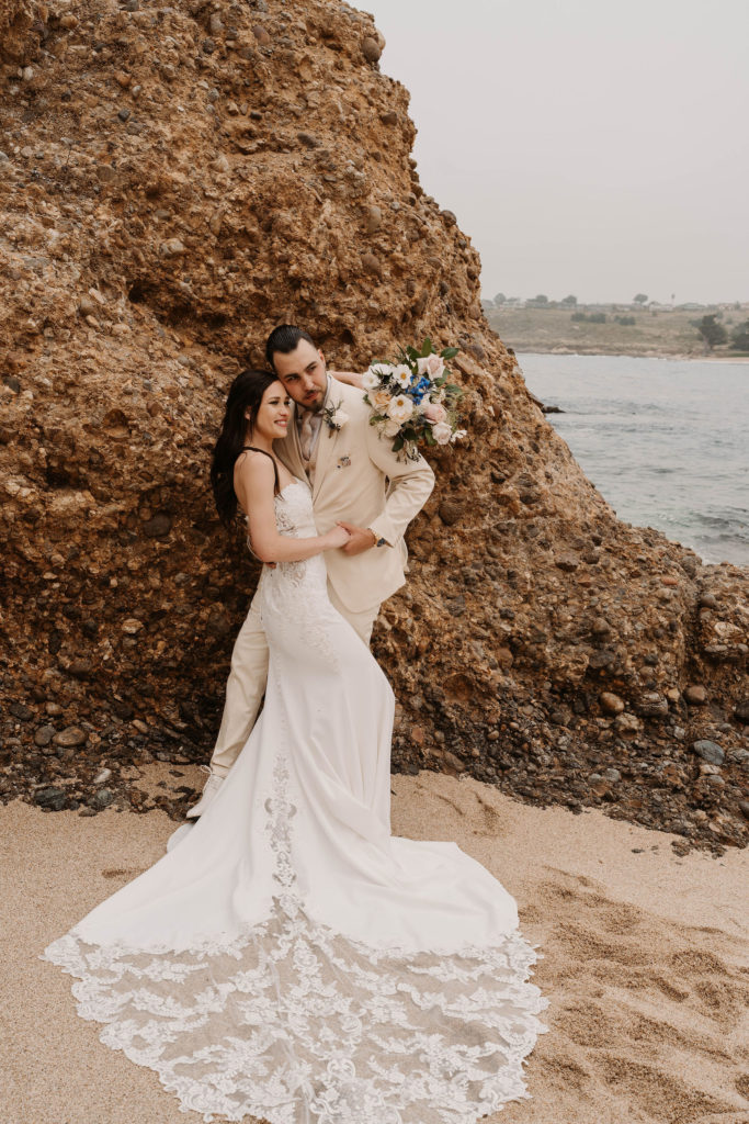 bride and groom posing on the beach