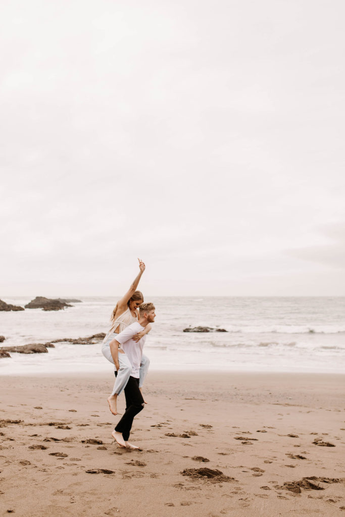 Couple piggybacking for photo shoot couple ideas and prompts on beach in San Francisco California