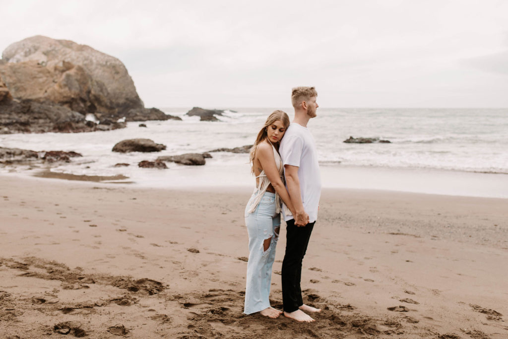 Couple being playful during couples session on the San Francisco beach