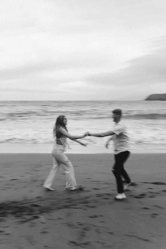 Couple being playful during couples session on the San Francisco beach