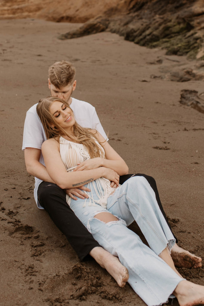 Couple being playful during couples session on the San Francisco beach