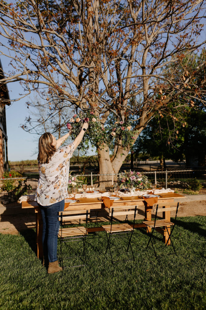 Florist setting up hanging flower baskets