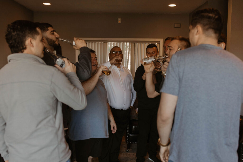 Groom and groomsman drinking before ceremony