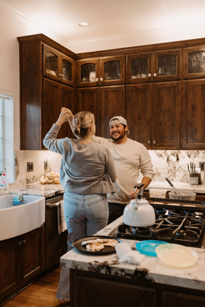 Couple making pancakes during in home couples session - Fun Couples Photoshoot Ideas