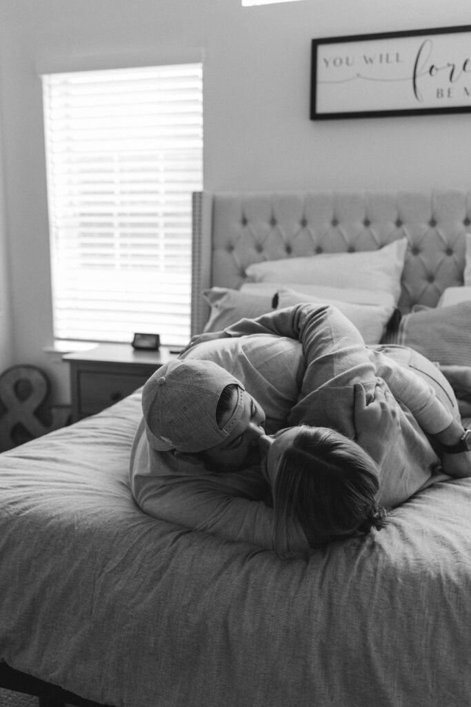 Couple posing on bed for in home couples session