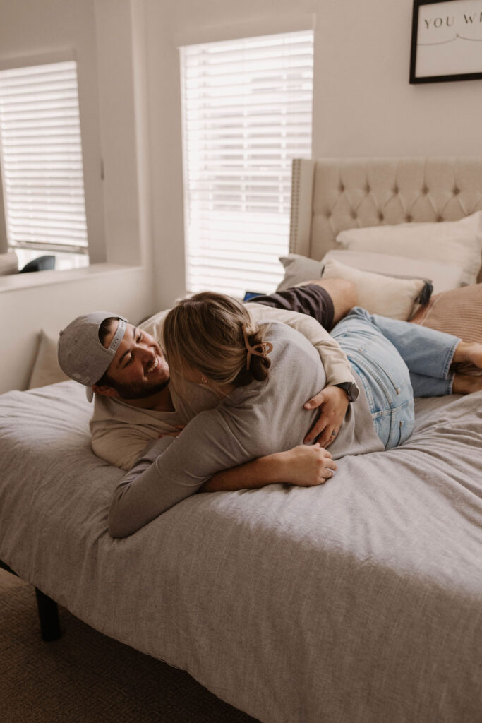 Couple laying on their bed during in home couples photos