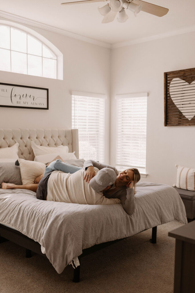 Couple laying on their bed during in home couples photos