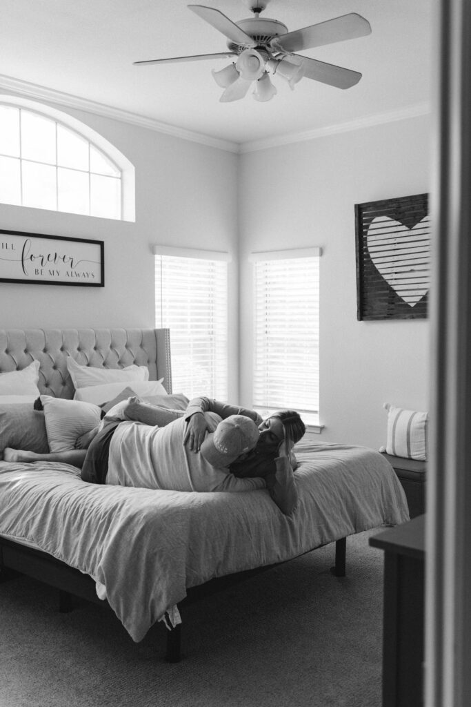 Couple posing on bed for in home couples session